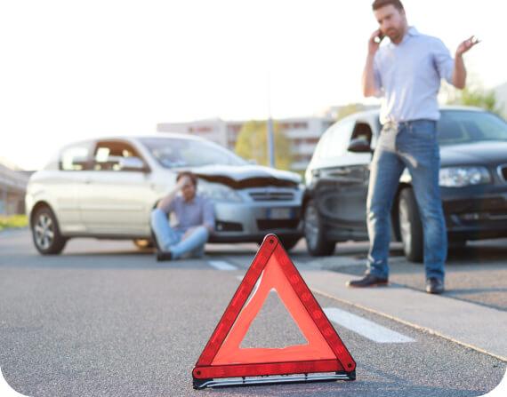 Warning triangle in front of an auto accident and two men