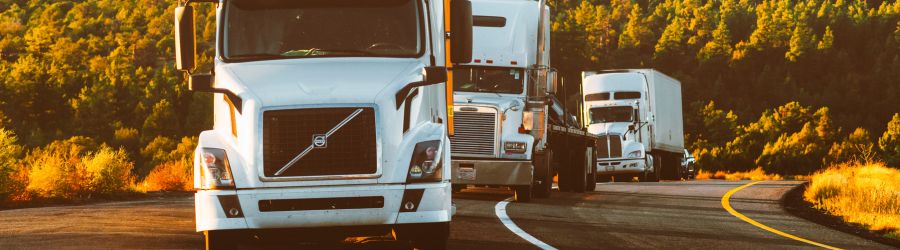 Three semi-trucks on the road