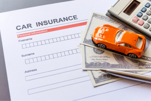 car insurance form with paper bills and calculator