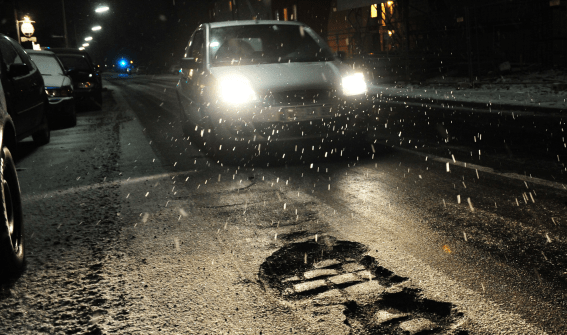 car on an icy road with potholes