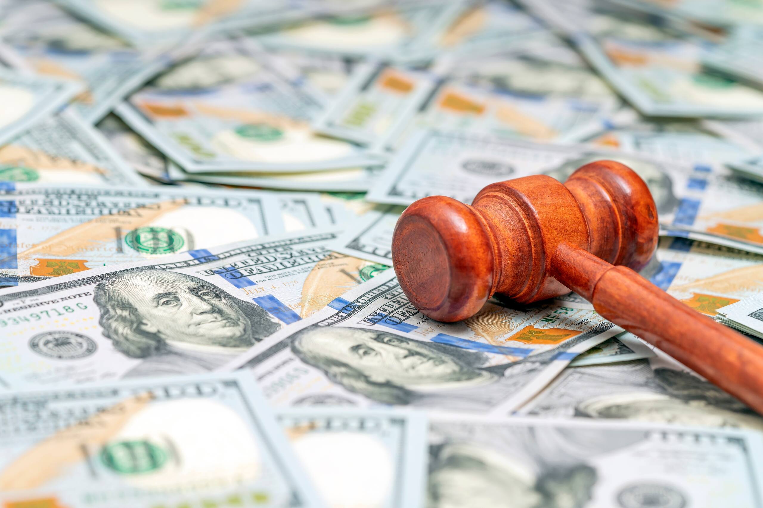Wooden gavel resting on dollar bills to represent the average slip and fall settlement in Florida.